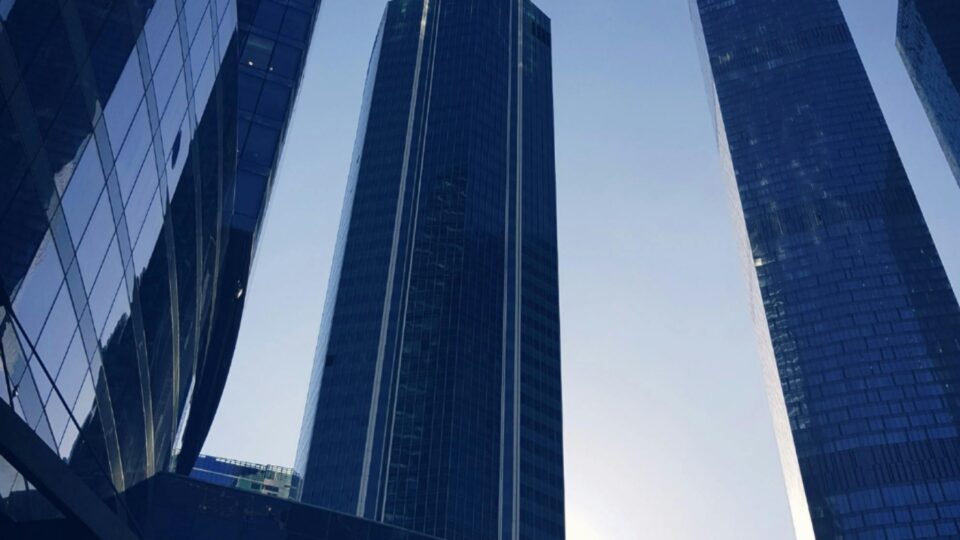 Low angle view of modern skyscrapers in Moscow with a striking morning sun backdrop.