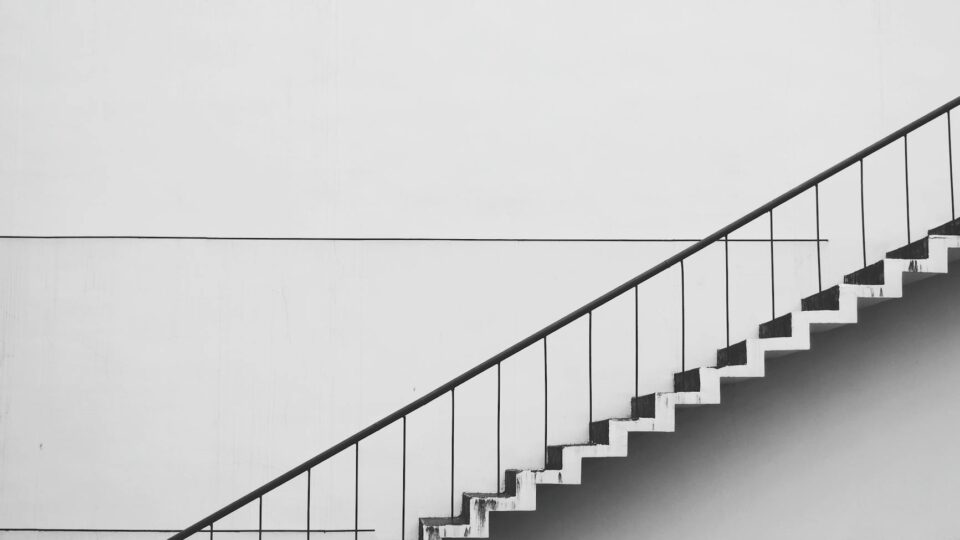 Minimalistic black and white staircase with sharp angles and clean lines, showcasing modern architecture.